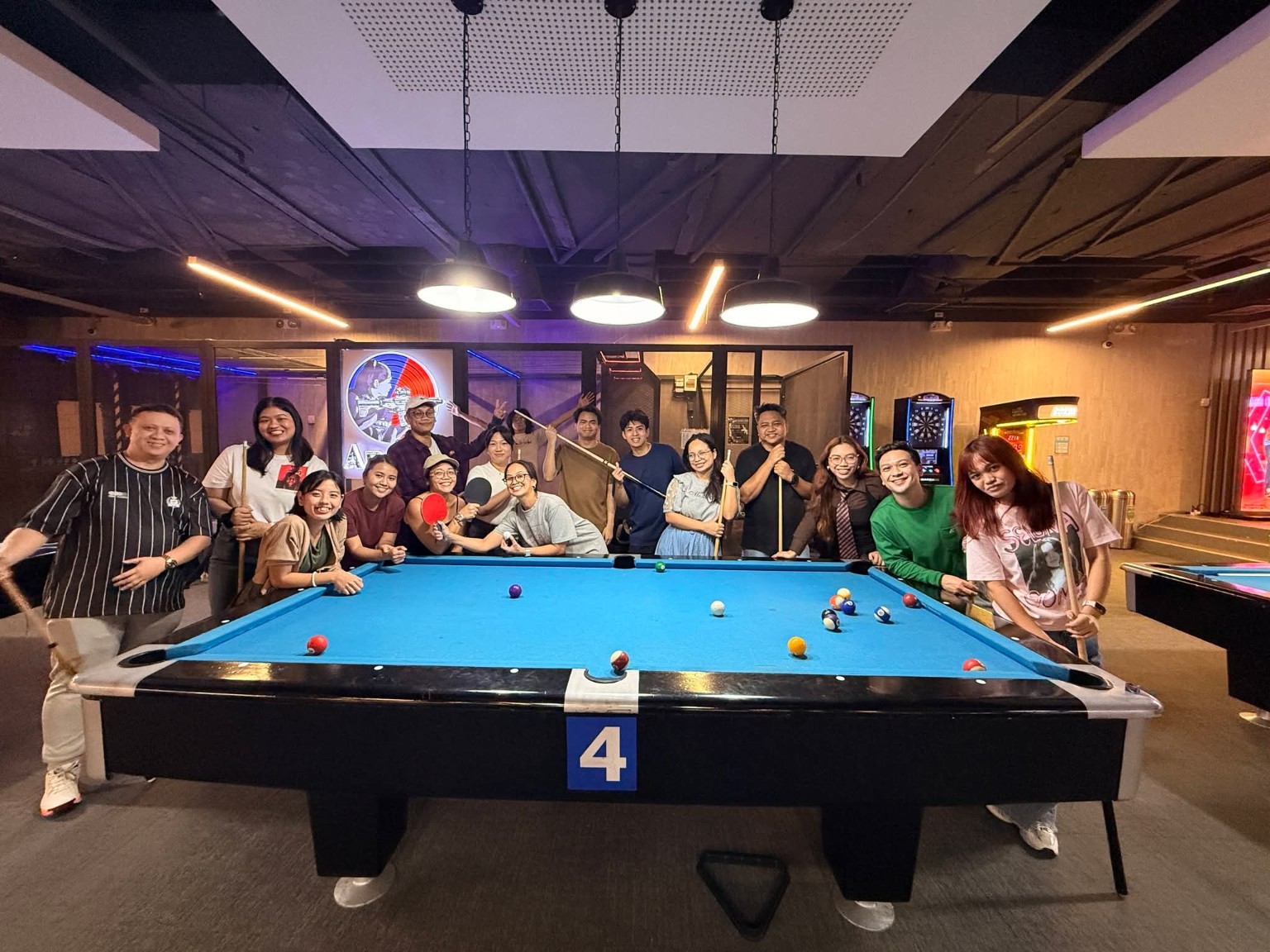 LeapOut colleagues gathered around a billiards table during a team gathering